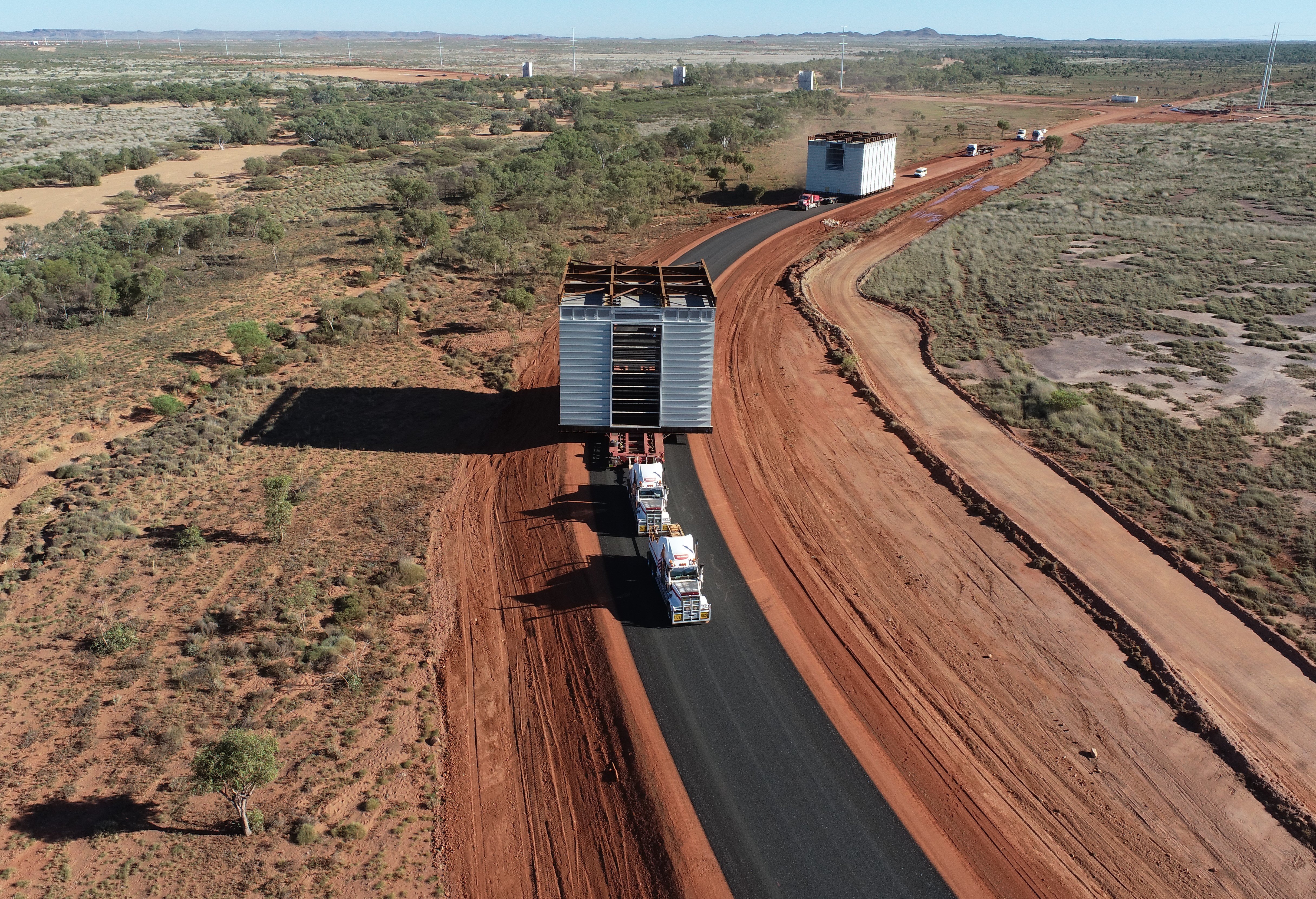 aerial image of oversize overmass truck load travelling on regional road with a large load