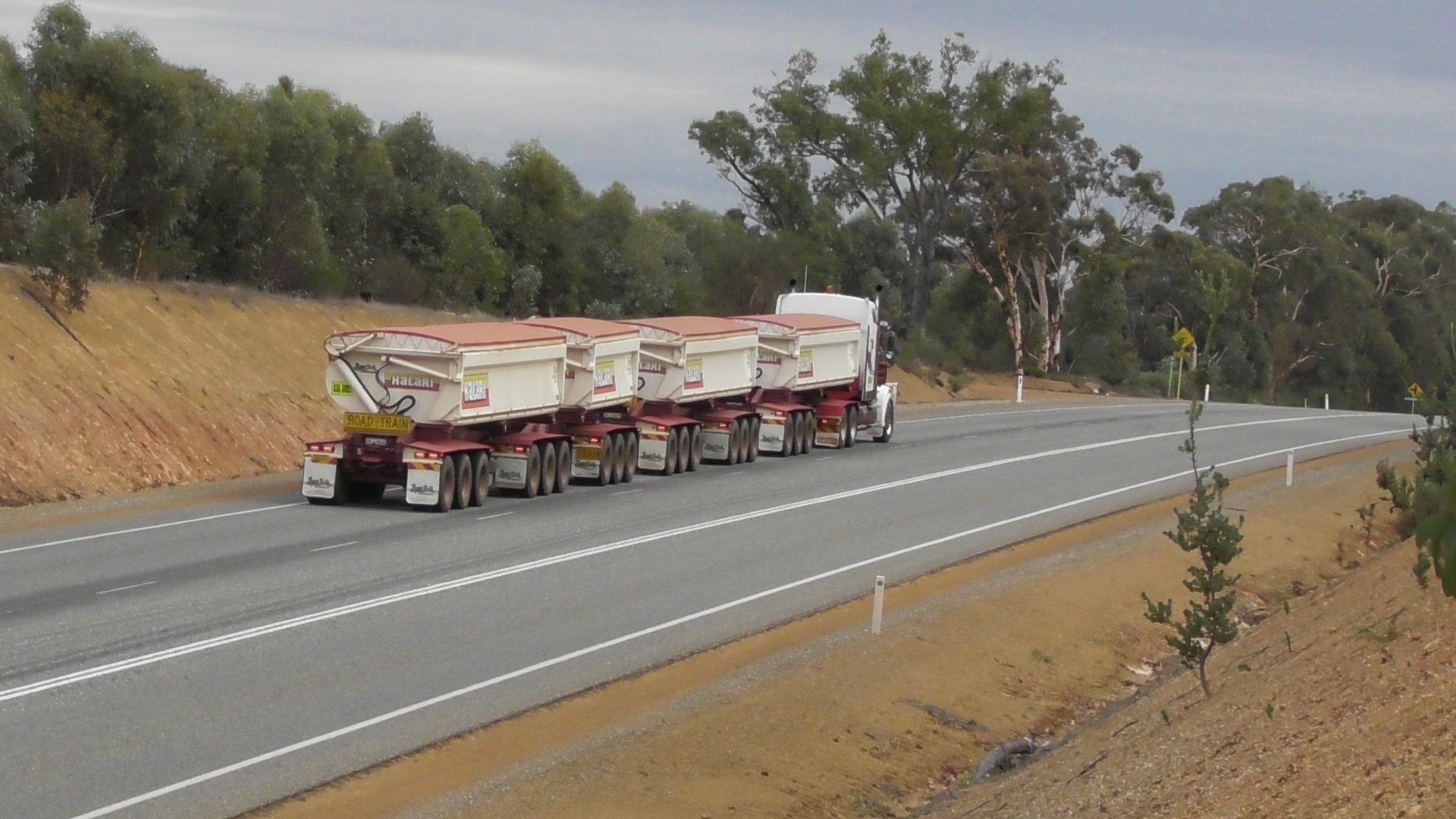 Quad Road Train travelling along a road away from the photographer