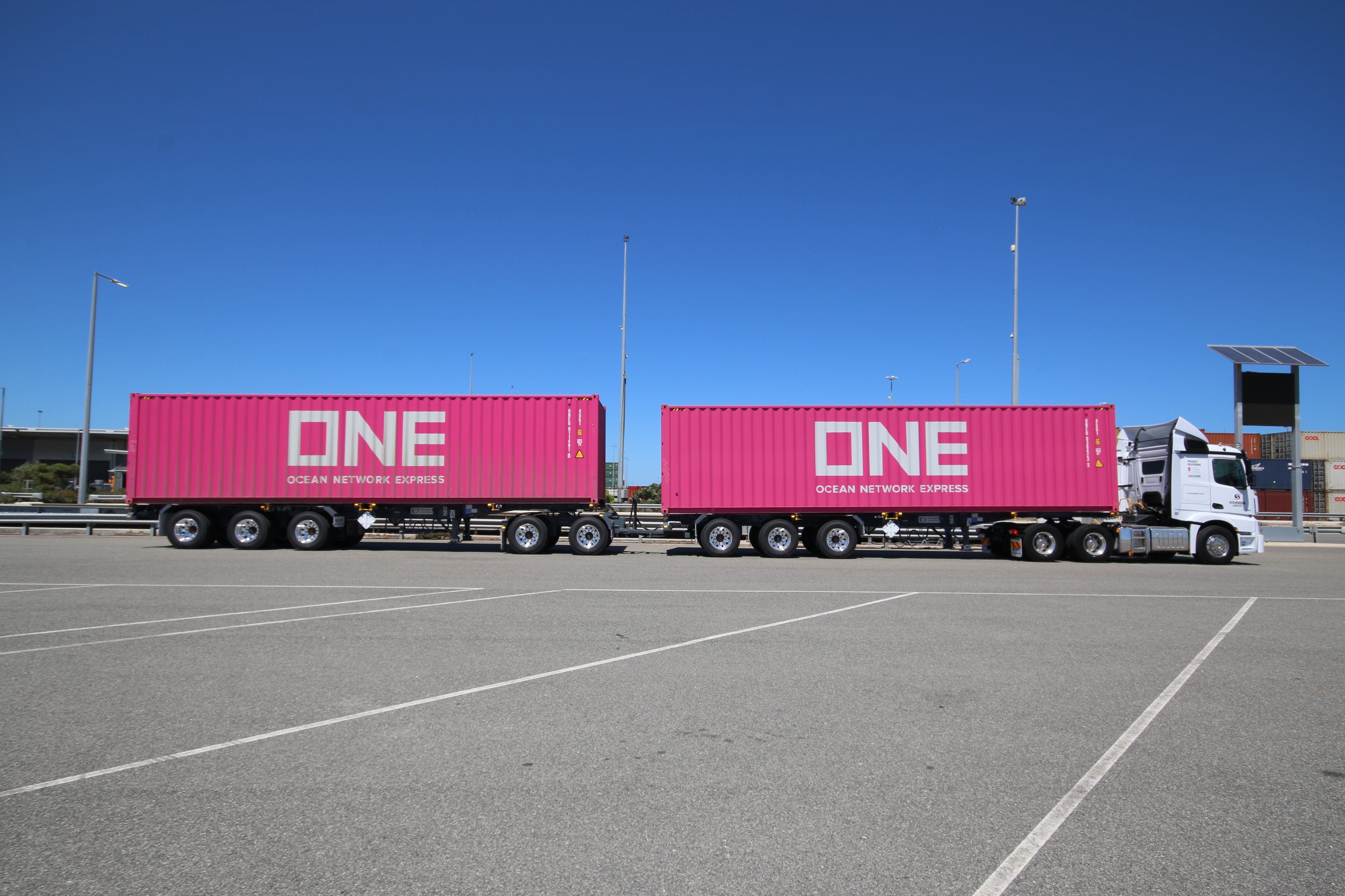 Road Train with two trailers with pink shipping containers parked in a carpark
