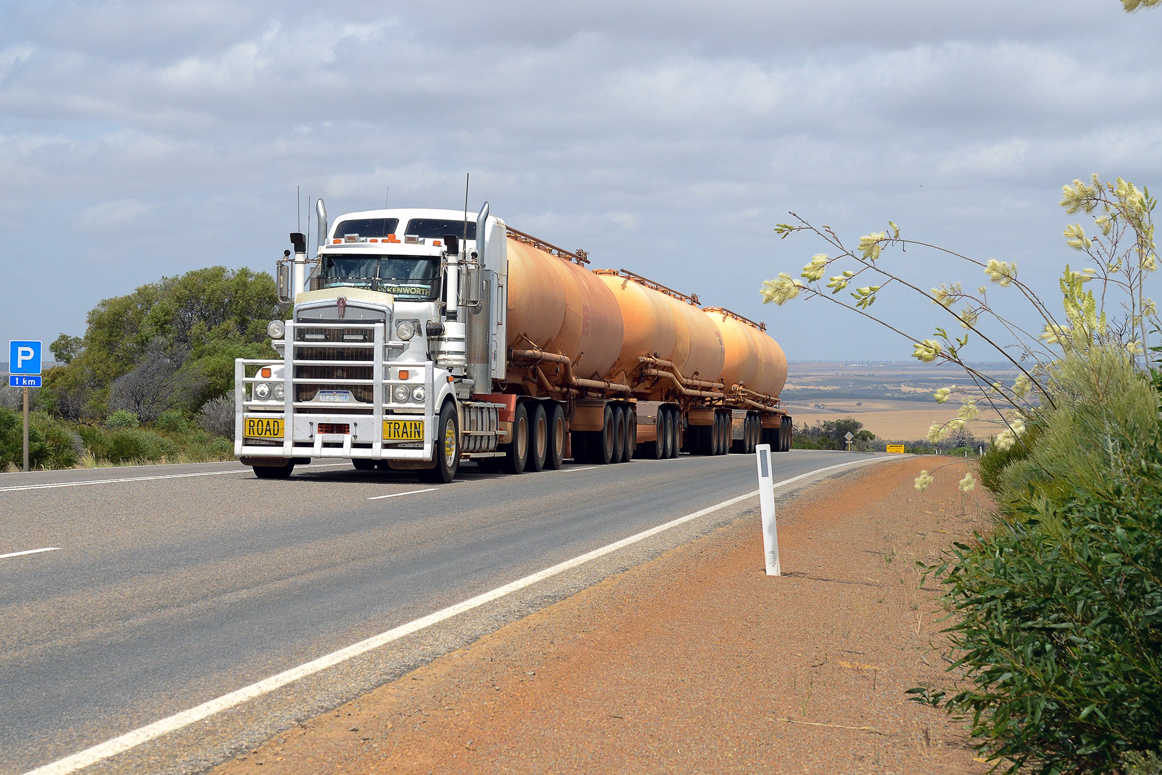 Road Train driving along a road towards the photographer towing three fuel tank trailers