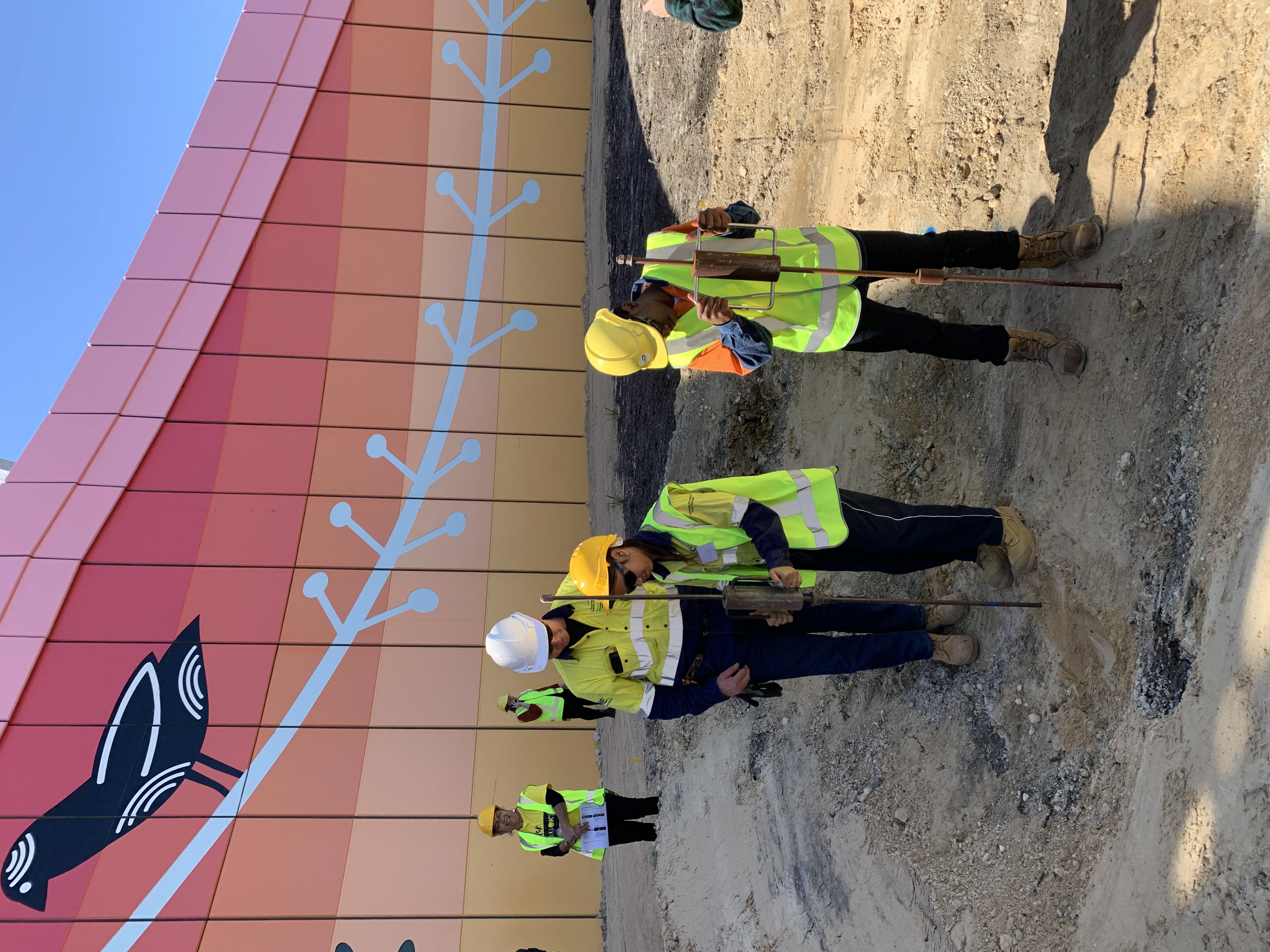 Students compacting sand on site