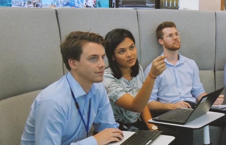 Students and graduates sitting in front of laptops