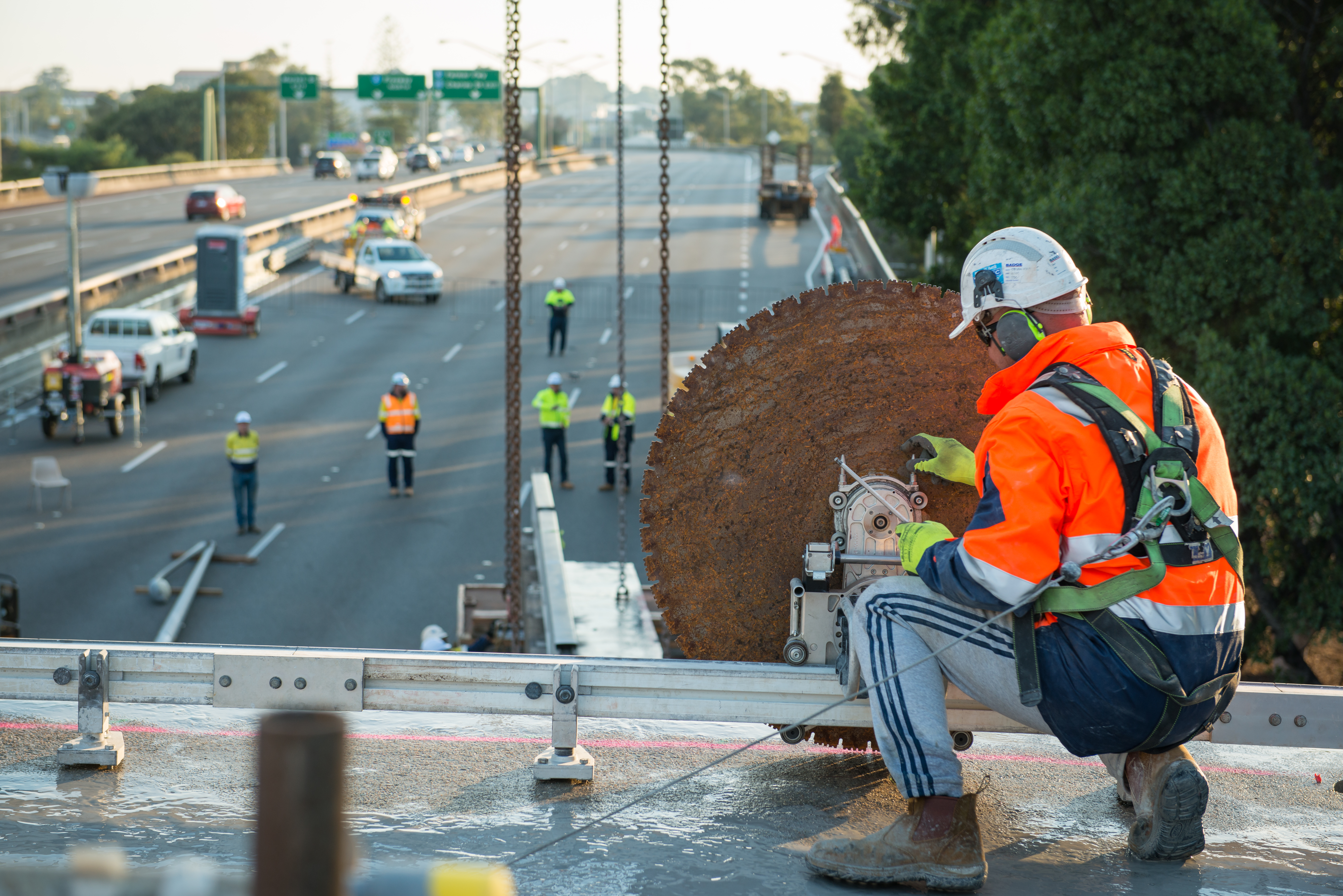A construction worker in Four female engineers in personal protective equipment on a bridge working with a large grinder