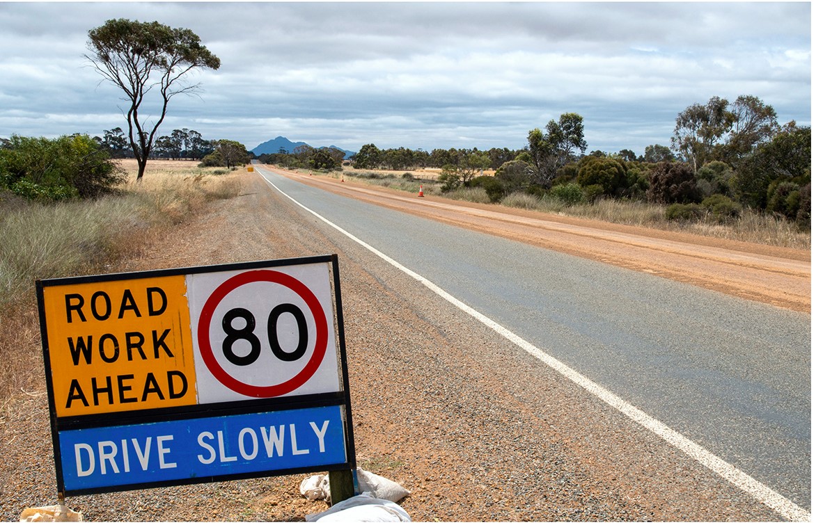 'Road Work Ahead - 80 Km h' speed sign on the side of the road