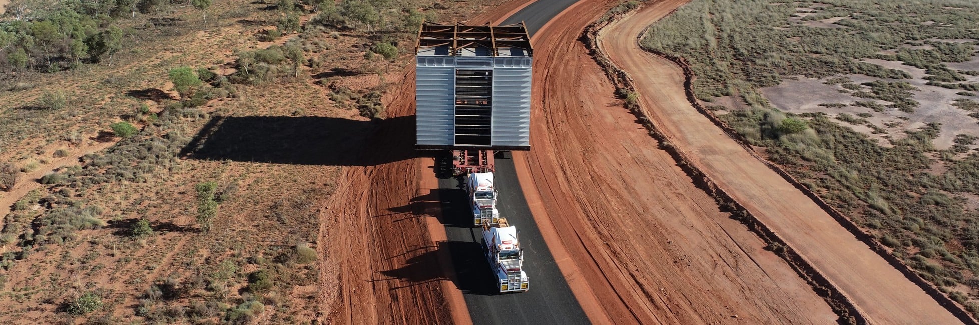 aerial image of oversize overmass truck load travelling on regional road with a large load