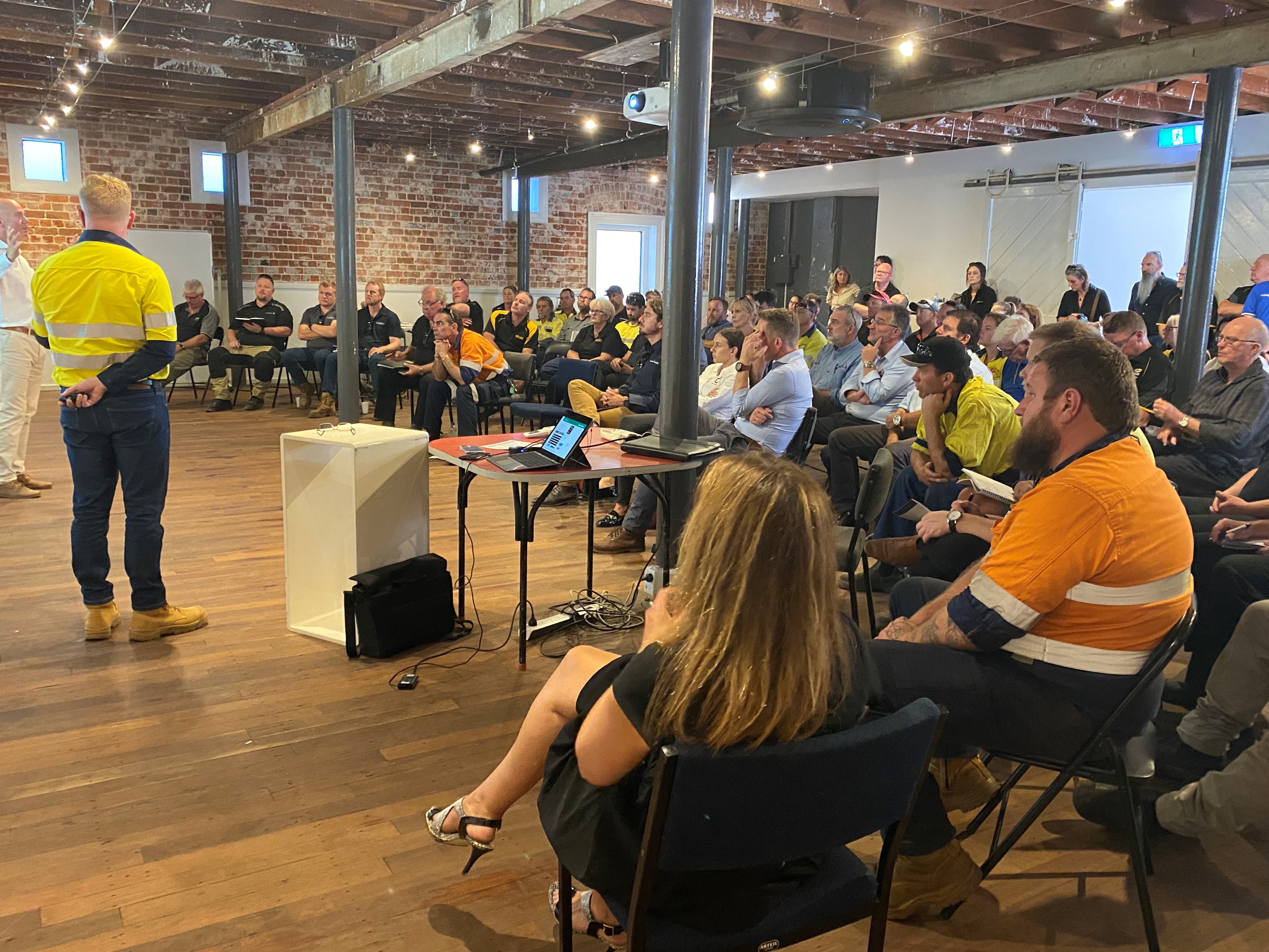 Community seated, listening to the project team at an information session