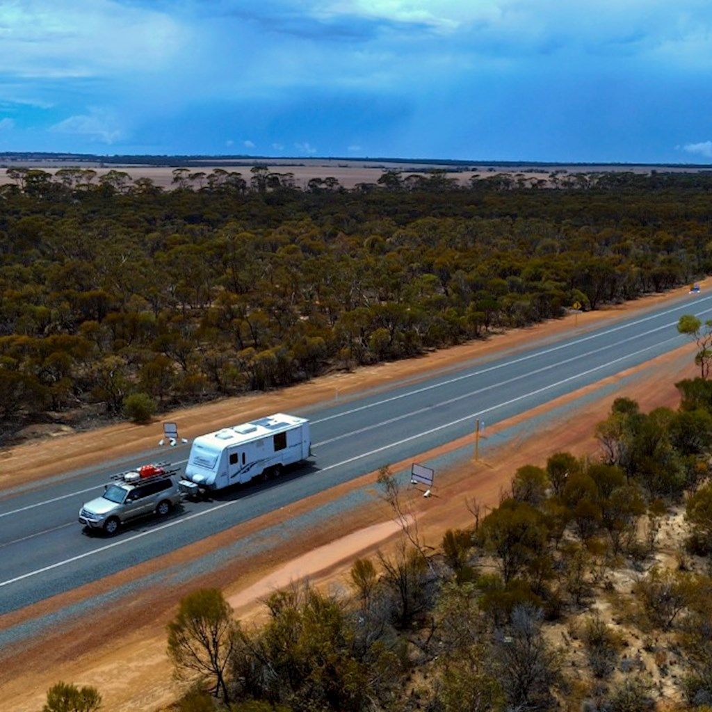 Car with a caravan driving along a regional road