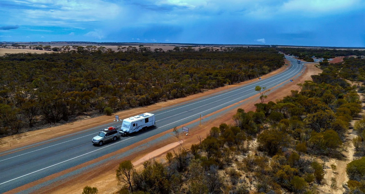 Car with a caravan driving along a regional road