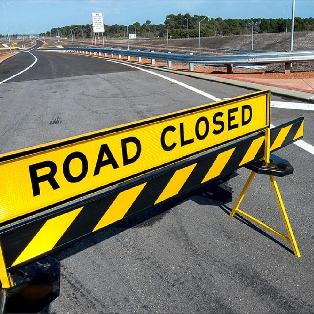 Sign blocking the road that says "road closed"