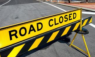Sign blocking the road that says "road closed"