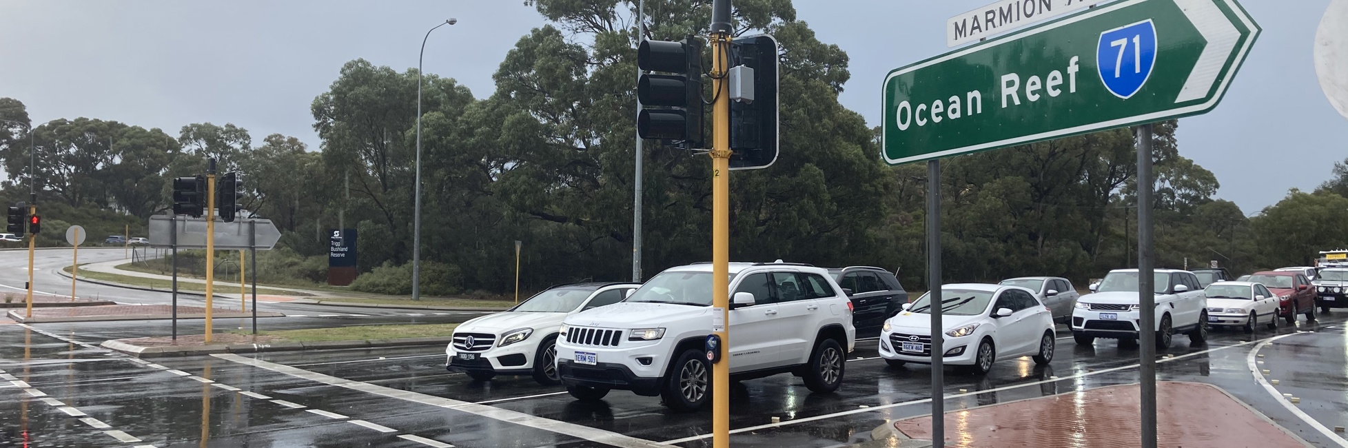 Traffic waiting at traffic lights with Marmion Avenue road sign